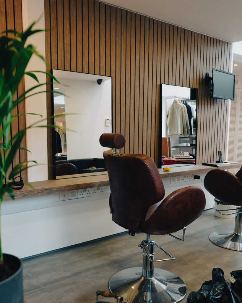 Image of barbershop chairs and mirrors propped up on a wall.