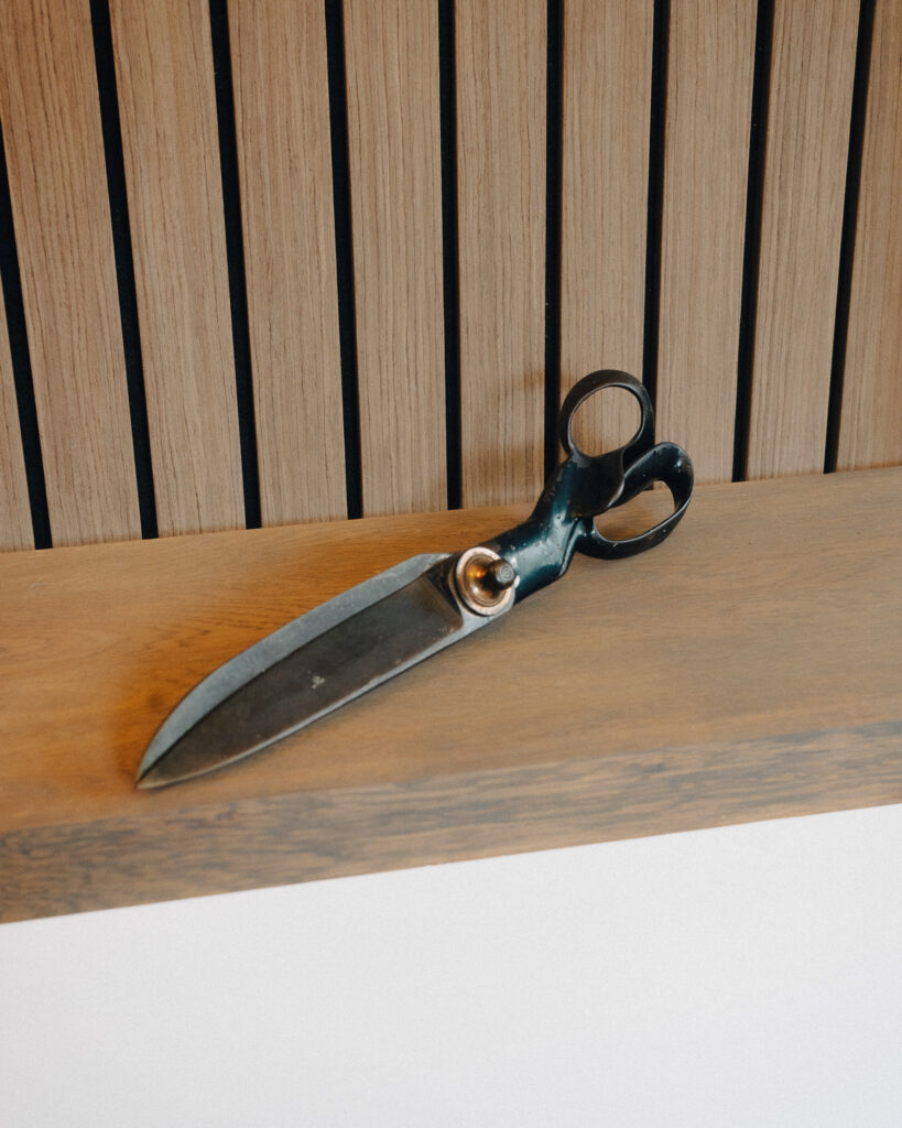 An image of vintage cutting shears on a shelf.